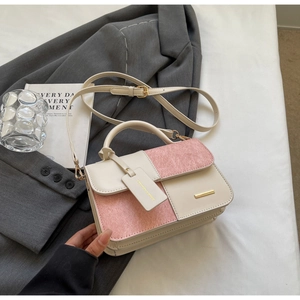 Dettaglio borsa a tracolla bicolore rosa e beige con finiture dorate e manico