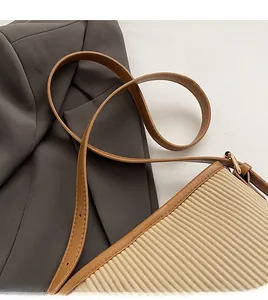 Detail of adjustable brown leather strap and pleated beige fabric with gold metal buckle