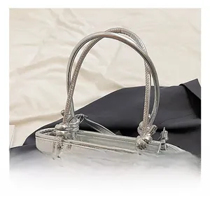 Detail showing metallic silver textured bucket bag with knotted handle and metal fastener