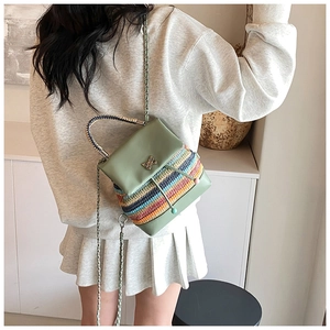 Détail du sac bandoulière tissé coloré avec rabat en cuir vert et papillon doré