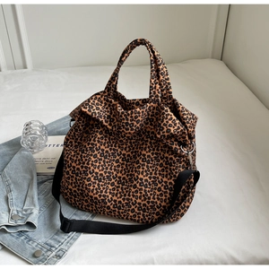 Dettaglio della borsa tote leopardata in tela con tracolla in nylon nero e anelli metallo