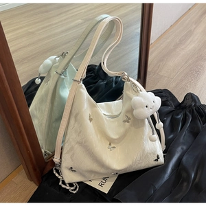 Dettaglio borsa a pieghe bianco off-white con farfalle metalliche e ciondolo nuvola
