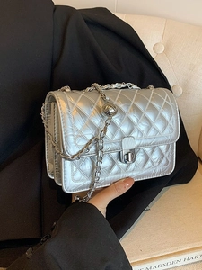 Silver quilted crossbody bag with metal chain strap and adjustable gold ball buckle