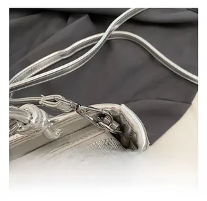 Close-up of metallic silver bucket bag showing durable metal hook and zipper hardware