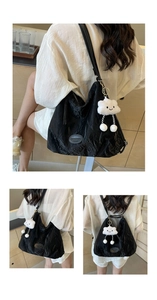 Détail du sac cabas plissé noir avec pendentif nuage blanc et logo de la marque