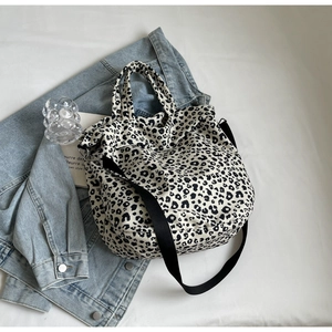 Dettaglio della borsa tote in tela leopardata su una giacca di jeans azzurra