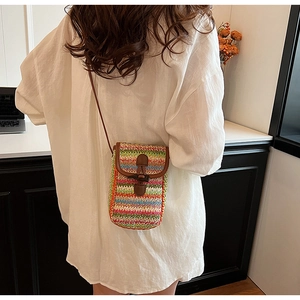 Detailed back view of a rainbow striped woven mini crossbody bag worn by a model