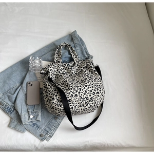 Dettaglio della borsa tote in tela leopardata con tracolla su una giacca di jeans