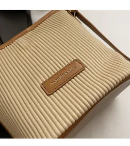 Detail of beige quilted fabric and brown leather patch with Fashion & Bag text