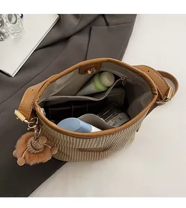 Top view of brown corduroy bucket bag interior with magnetic closure and inner zip pocket