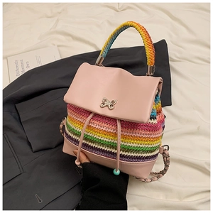 Détail du rabat en cuir rose avec boucle papillon et texture tissée arc-en-ciel du sac