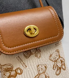 Dettaglio della stampa vintage teddy bear e della chiusura dorata sulla borsa a tracolla