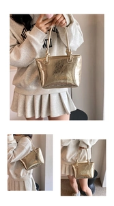 Detail of metallic gold pleated tote bag with unique knotted handle and textured surface