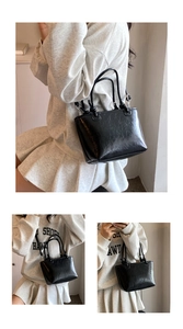 Detail of glossy black crinkle leather bucket bag with silver hardware and adjustable strap