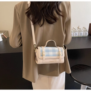 Checkered crossbody bag featuring cream and blue tweed fabric on a stylish model
