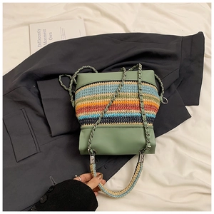 Détail de la texture tissée multicolore et bandoulière chaîne du petit sac vert