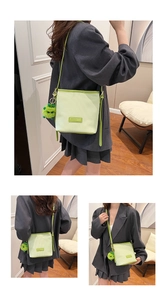 Close-up of light green corduroy bucket bag with vertical texture and monster charm