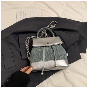 Détail du mini sac à dos en jean et cuir argenté avec motif matelassé et nœud en métal