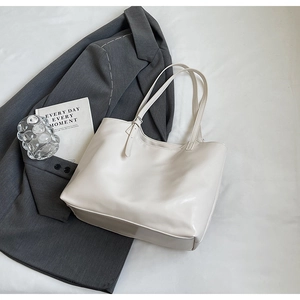 Minimalist white leather tote bag styled with gray suit and book for chic office aesthetic