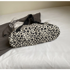 Primer plano detallado del bolso de lona con estampado de leopardo y asas negras