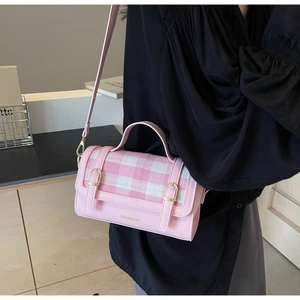 Detailed view of pink and white checkered crossbody bag with gold buckle hardware