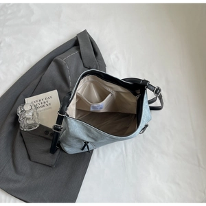 Detail view of spacious blue canvas tote with inner zipper pocket and black PU strap