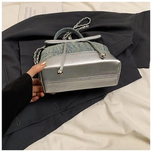 Détail du mini sac à dos patchwork en denim bleu et argent avec bandoulière chaîne