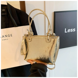 Close-up of metallic gold bucket bag with wrinkled texture and knotted handle detail
