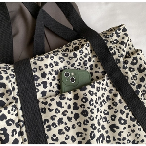 Primer plano de bolso tote de lona con estampado de leopardo y bolsillo exterior