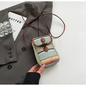 Close-up of a rainbow-striped woven mini crossbody bag with a brown leather strap