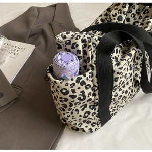 Detalle del bolso tote de leopardo con un práctico bolsillo lateral para paraguas