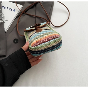 Detail of colorful striped straw phone bag with wood toggle and leather strap