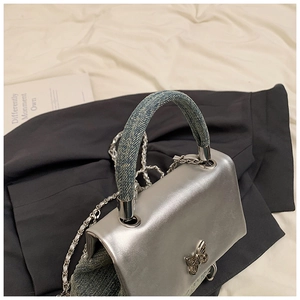 Détails du sac à main argenté avec côtés en denim et boucle papillon en métal argenté