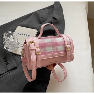 Detail of pink leather handbag with plaid pattern flap and golden metal clasp buckle