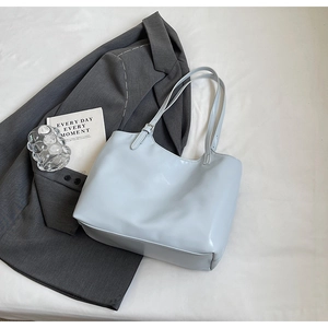 Detail of light blue patent leather tote bag showing silver metal adjustment buckle