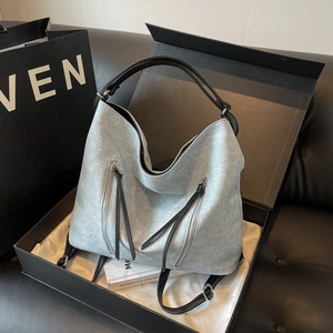 Large grey fabric tote bag with silver zippers and black handles in a gift box setup