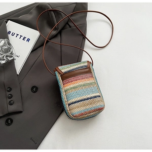 Detail of rainbow woven phone bag with brown leather trim on grey blazer background