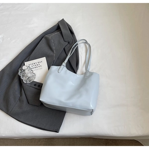 Macro shot of light blue minimalist tote bag with adjustable straps and smooth texture