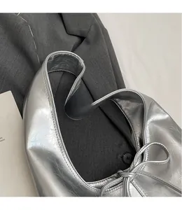 Close-up of metallic silver hobo bag featuring premium wrinkled texture and wide shoulder strap