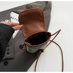 Detailed interior of a mini rainbow woven straw crossbody bag with brown PU leather flap