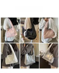Detail view of large silver shoulder bags with drawstring bows in four different colors