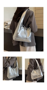 Close-up of metallic silver hobo bag featuring bow detail and heart metal emblem