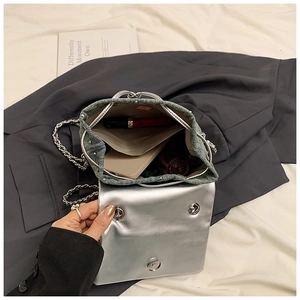 Détail du sac en denim et cuir argenté montrant l'espace pour téléphone et rouge à lèvres