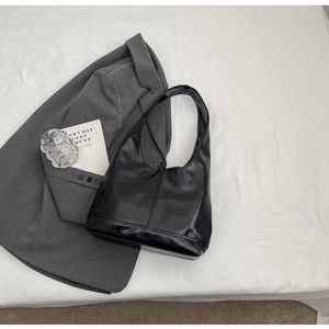 Macro detail of high-quality black faux leather texture on a modern hobo shoulder bag