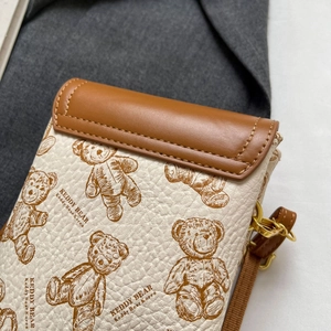 Detail der Crossbody-Handytasche mit Teddybär-Mustern und Litchi-Leder-Textur im Detail