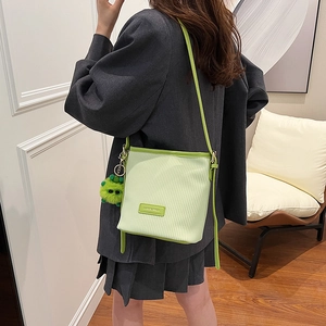 Lime green pleated bucket bag with adjustable strap and cute plush monster charm