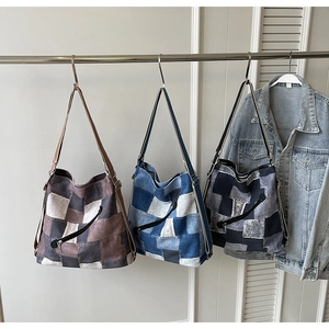 Detailed view of color-block denim tote bags with patchwork design and wide straps