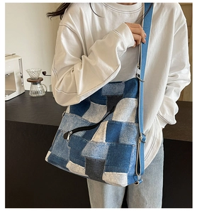 Detail of patchwork denim tote bag with diagonal zipper pocket and adjustable strap