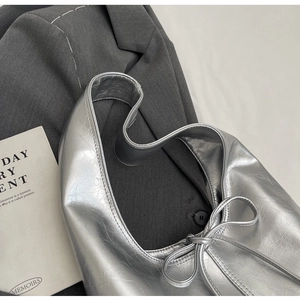 Detail of silver metallic tote bag showing bow tie and textured wrinkled finish