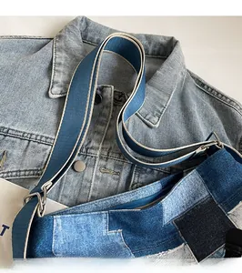 Detail of blue denim patchwork tote with smooth adjustable fabric shoulder strap